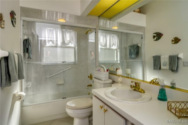 full bathroom with combined bath / shower with glass door, vanity, toilet, and a healthy amount of sunlight