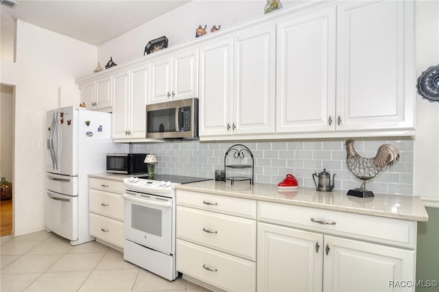 kitchen with white cabinetry, light stone counters, white appliances, decorative backsplash, and light tile patterned floors