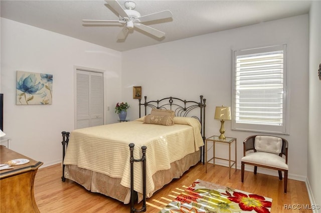 bedroom featuring ceiling fan, wood-type flooring, and a closet