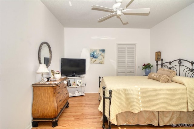 bedroom featuring ceiling fan, light hardwood / wood-style floors, and a closet