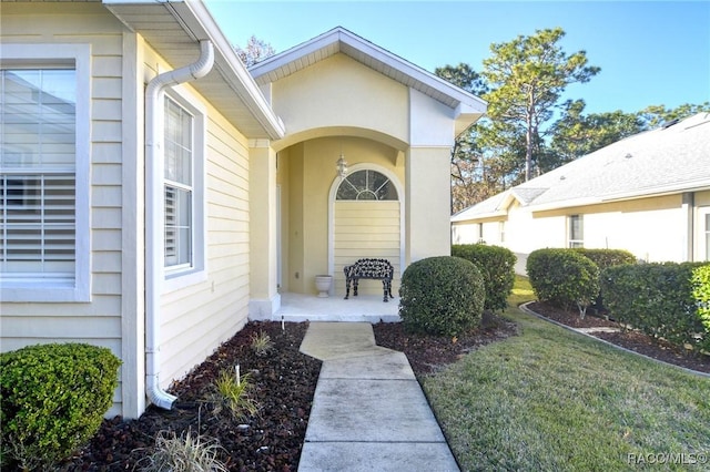 doorway to property with a lawn