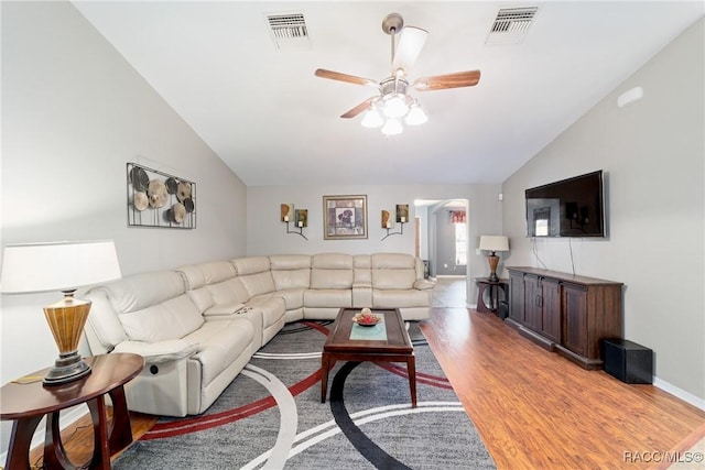 living area with ceiling fan, wood finished floors, visible vents, and vaulted ceiling