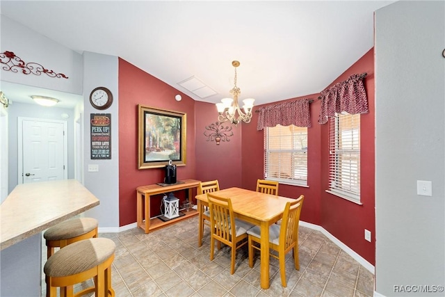 dining space featuring lofted ceiling, a notable chandelier, and baseboards