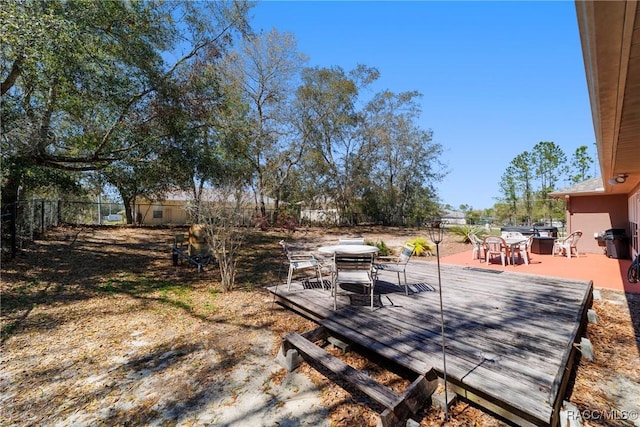 deck featuring outdoor dining area and a fenced backyard
