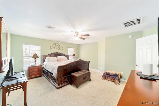 bedroom with light colored carpet, visible vents, baseboards, and ceiling fan