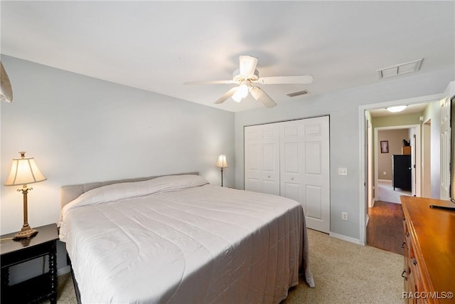 bedroom with baseboards, light carpet, a closet, and visible vents