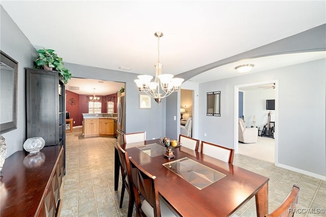 dining room featuring an inviting chandelier, light tile patterned floors, and arched walkways