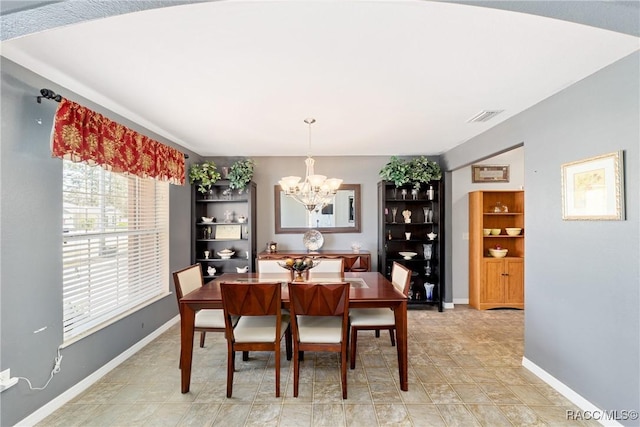dining space with baseboards, a notable chandelier, and visible vents