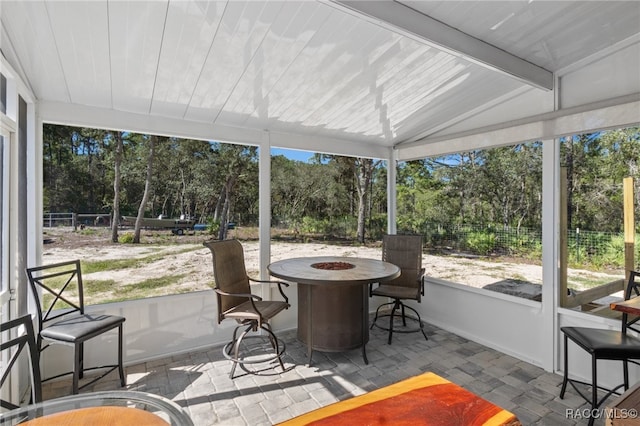 sunroom / solarium with vaulted ceiling with beams and a wealth of natural light