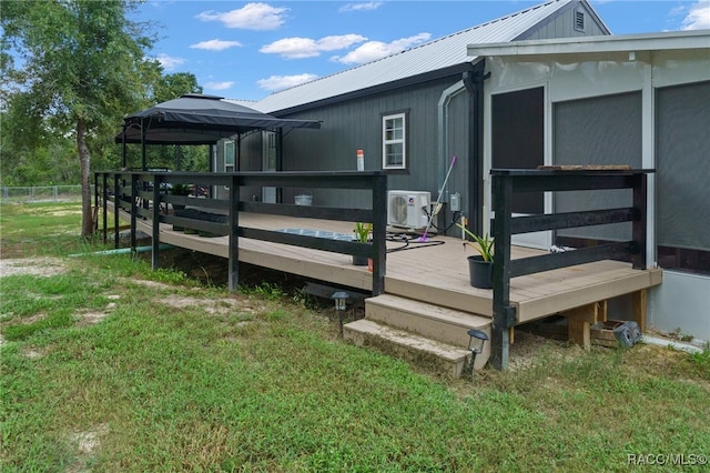 wooden terrace with a gazebo, ac unit, and a yard