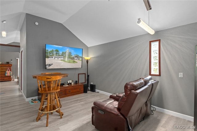 home theater room featuring light wood-type flooring and lofted ceiling