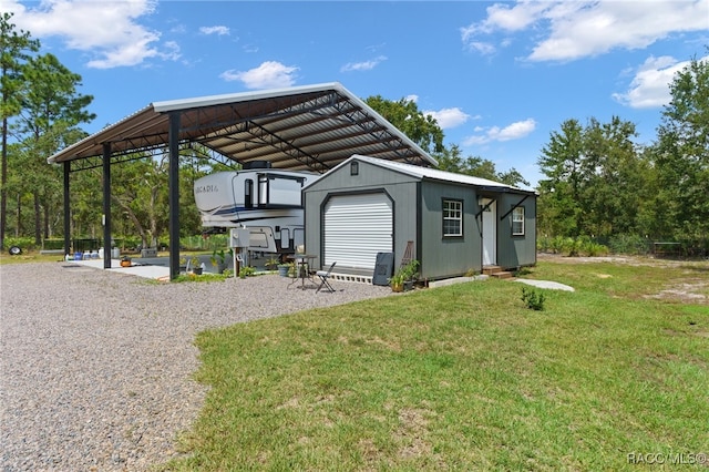 view of outbuilding with a lawn, a garage, and a carport