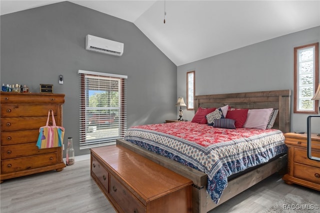 bedroom with lofted ceiling, light hardwood / wood-style floors, and a wall mounted air conditioner