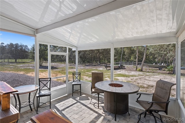 sunroom featuring lofted ceiling with beams and a wealth of natural light