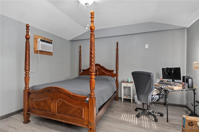 bedroom with light hardwood / wood-style flooring, vaulted ceiling, and a wall unit AC