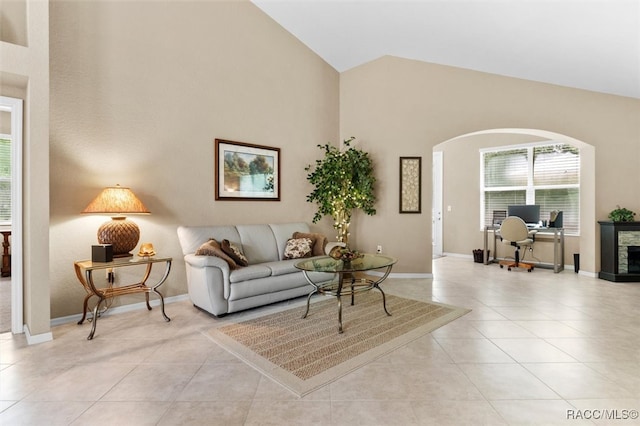 living room featuring a fireplace, lofted ceiling, and light tile patterned flooring