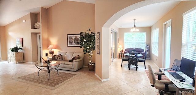 living room with light tile patterned floors, an inviting chandelier, and plenty of natural light