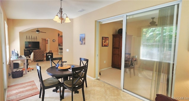 dining space with ceiling fan with notable chandelier and light tile patterned floors