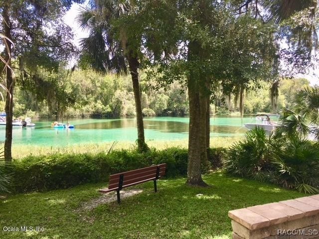 view of community with a lawn and a water view