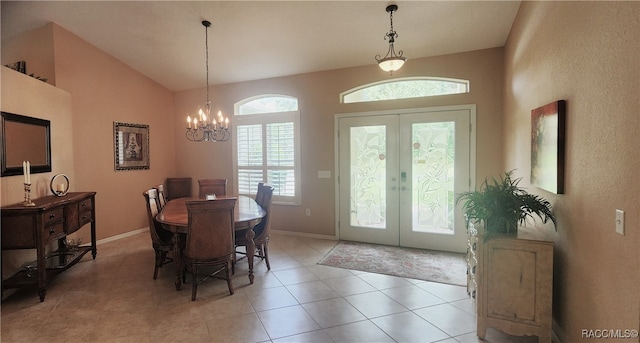 tiled dining space featuring an inviting chandelier, lofted ceiling, and french doors