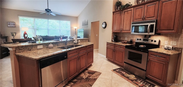 kitchen with sink, stainless steel appliances, tasteful backsplash, lofted ceiling, and light tile patterned floors