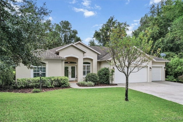 ranch-style house featuring french doors, a front lawn, and a garage