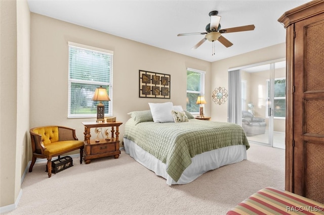 bedroom with ceiling fan, ensuite bathroom, and light colored carpet