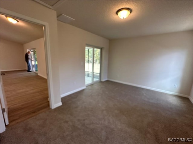 carpeted spare room featuring a textured ceiling