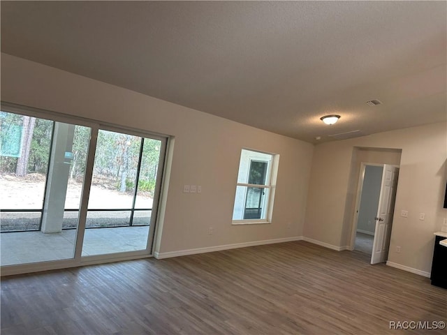 unfurnished room with dark wood-type flooring and a textured ceiling