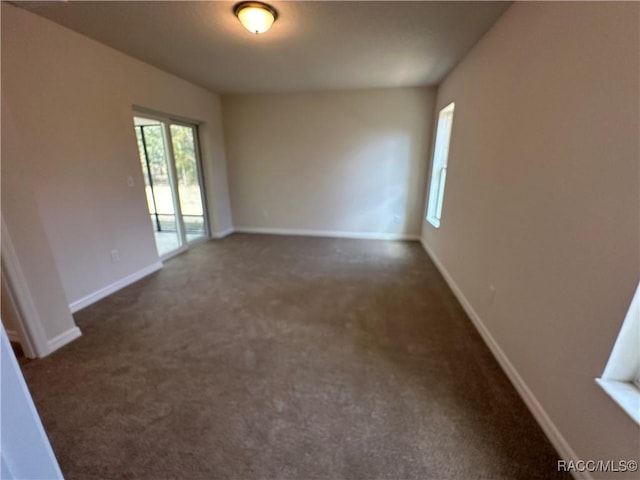 empty room featuring dark carpet