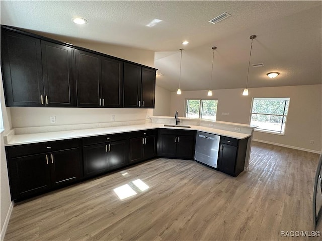 kitchen with pendant lighting, dishwasher, lofted ceiling, light hardwood / wood-style floors, and kitchen peninsula