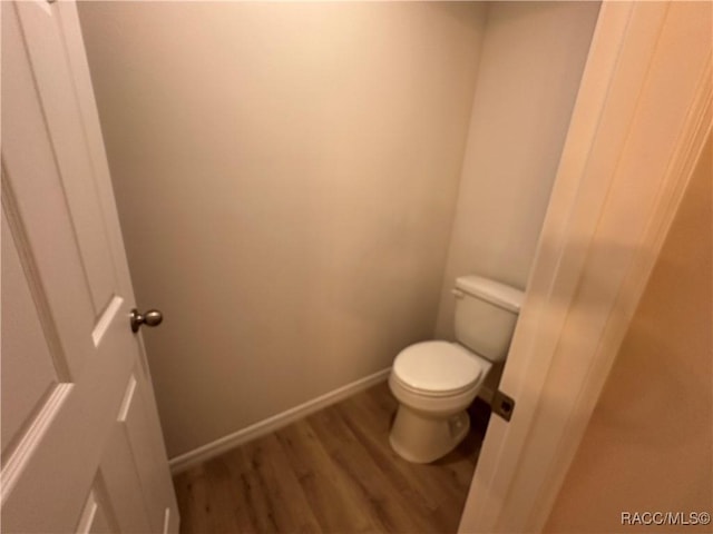 bathroom with wood-type flooring and toilet