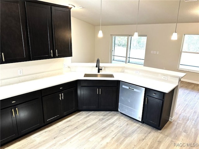 kitchen with sink, decorative light fixtures, stainless steel dishwasher, and kitchen peninsula