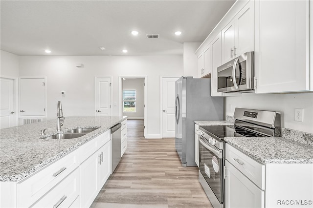 kitchen featuring sink, light hardwood / wood-style flooring, light stone countertops, white cabinetry, and stainless steel appliances