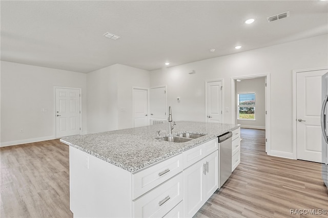 kitchen with light wood-type flooring, stainless steel dishwasher, a kitchen island with sink, and sink