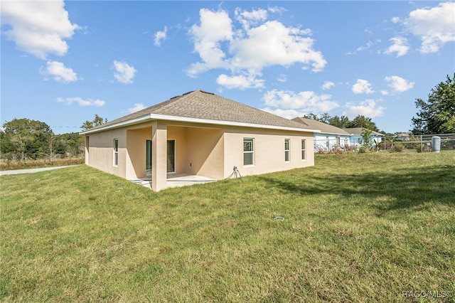 back of property featuring a lawn and a patio