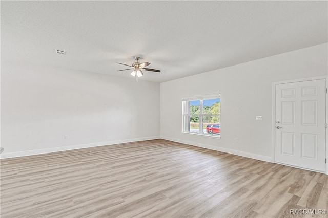 empty room featuring ceiling fan, light hardwood / wood-style floors, and a textured ceiling