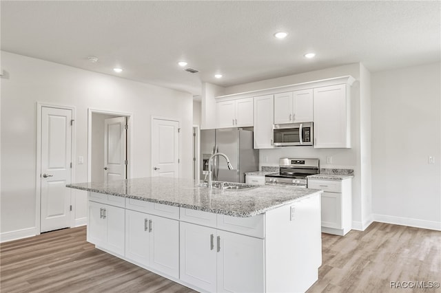 kitchen featuring a center island with sink, white cabinets, stainless steel appliances, and sink