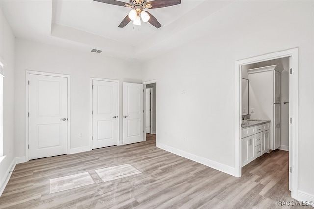 unfurnished bedroom with ensuite bathroom, sink, ceiling fan, and light hardwood / wood-style floors