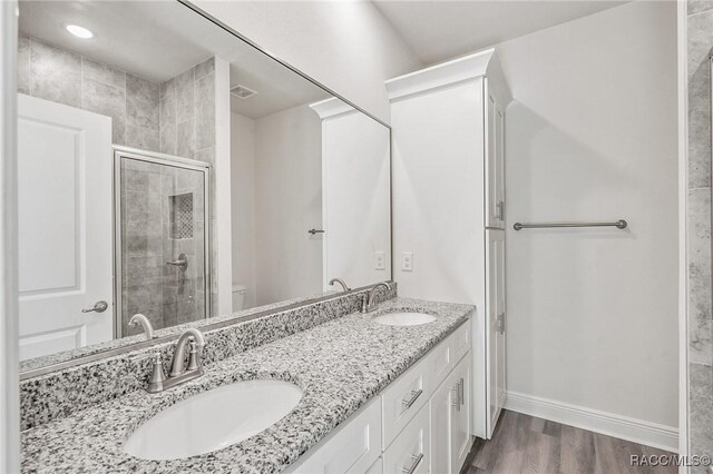 44 W Lynnhaven Pl, Citrus Springs, FL 34434 - full bathroom featuring double vanity, a shower stall, baseboards, wood finished floors, and toilet