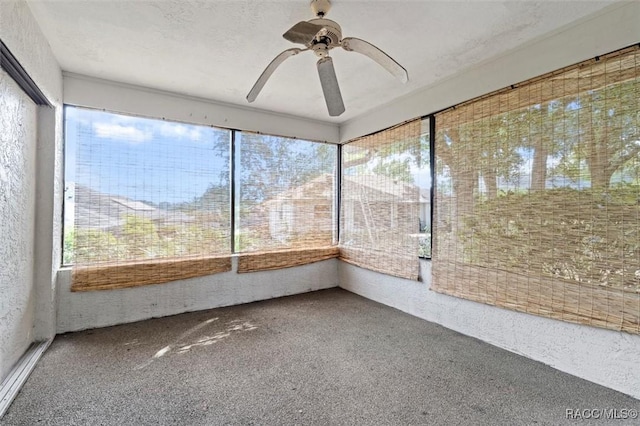 unfurnished sunroom with a ceiling fan and a wealth of natural light