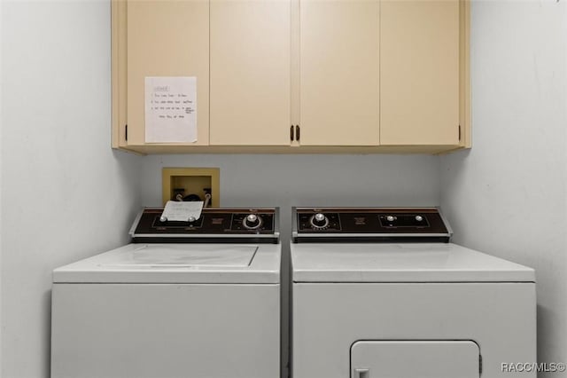 clothes washing area with cabinet space and washing machine and dryer