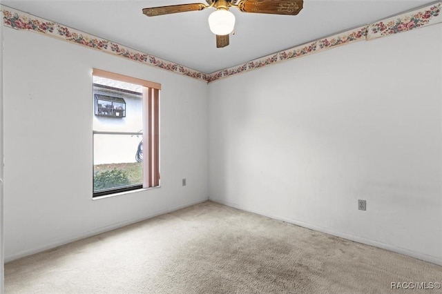 unfurnished room with carpet floors, baseboards, and a ceiling fan