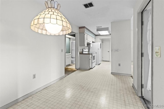 interior space with light floors, baseboards, and visible vents