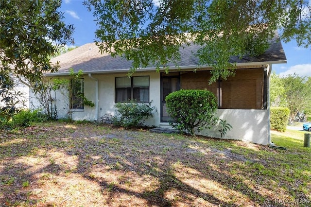 view of front of property with roof with shingles and stucco siding