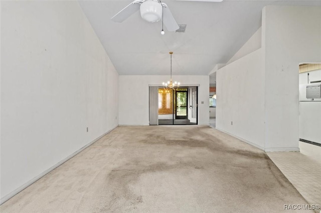 spare room featuring carpet flooring, visible vents, lofted ceiling, and ceiling fan with notable chandelier