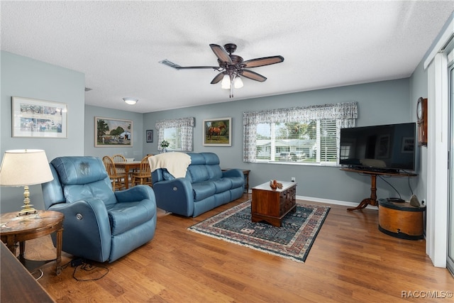 living room with wood-type flooring, a textured ceiling, and ceiling fan