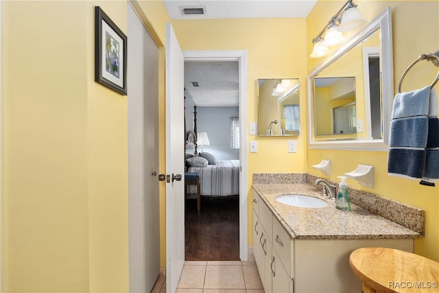 bathroom with tile patterned floors, vanity, and a textured ceiling