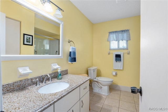 bathroom with tile patterned flooring, vanity, a shower with shower door, and toilet