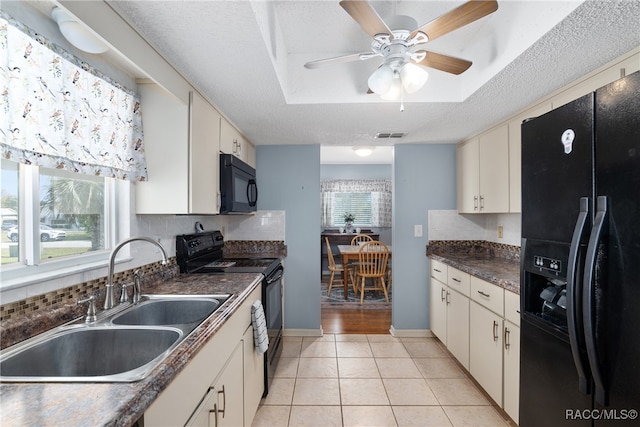 kitchen featuring sink, a textured ceiling, a healthy amount of sunlight, and black appliances